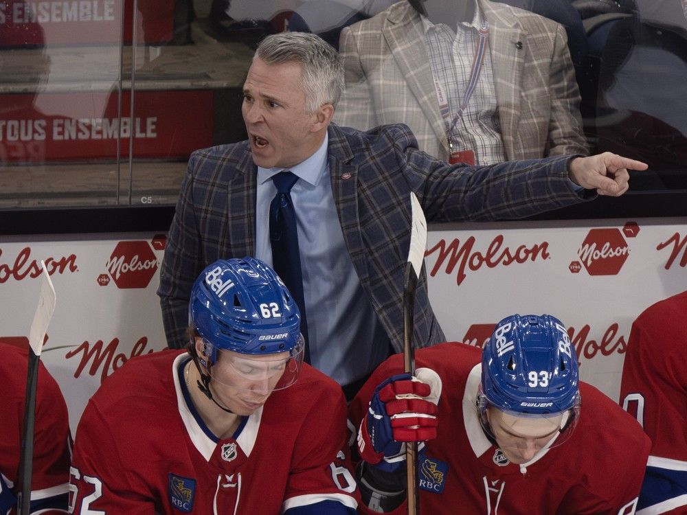 Canadiens head coach Martin St. Louis points to the ice while standing behind Owen Beck, left, and Ivan Demidov against the Chicago Blackhawks in Montreal on Dec. 18, 2025.