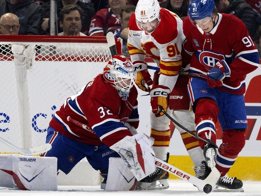 Canadiens goaltender Jacob Fowler tries to reel in loose puck as Calgary Flames' Nazem Kadri and Oliver Kapanen battle for position during third period in Montreal on Jan. 7.