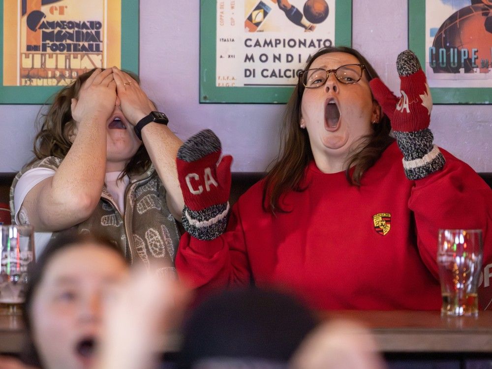 Carliina Robinson, left, and Claire Duschenes-Best react as the USA wins the gold medal in overtime against Canada's women's hockey team while watching the game at Champs bar in Montreal on Thursday, Feb. 19, 2026.