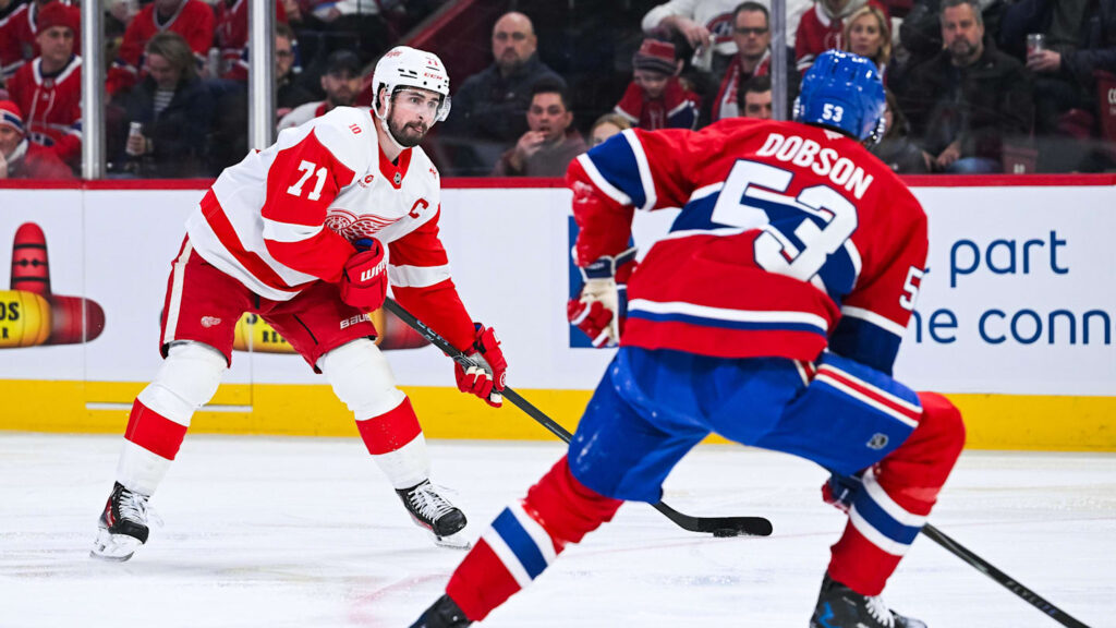 Jan 10, 2026; Montreal, Quebec, CAN; Detroit Red Wings center Dylan Larkin (71) plays the puck against Montreal Canadiens defenseman Noah Dobson (53) during the second period at Bell Centre. Mandatory Credit: David Kirouac-Imagn Images