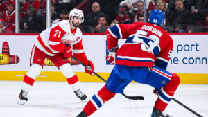 Jan 10, 2026; Montreal, Quebec, CAN; Detroit Red Wings center Dylan Larkin (71) plays the puck against Montreal Canadiens defenseman Noah Dobson (53) during the second period at Bell Centre. Mandatory Credit: David Kirouac-Imagn Images