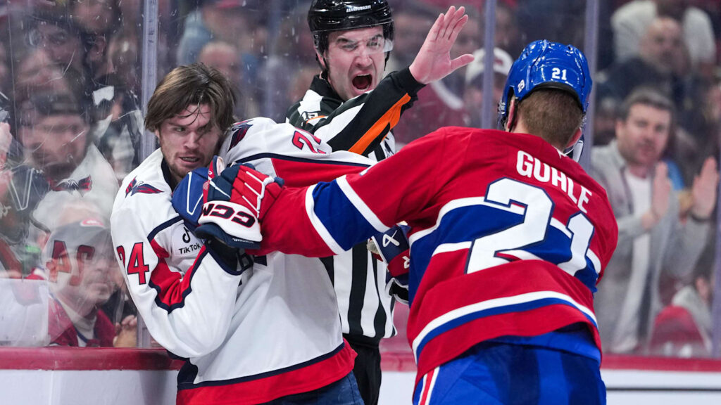 Feb 28, 2026; Montreal, Quebec, CAN; referee Cody Beach (12) stops the fight between Washington Capitals forward Connor McMichael (24) and Montreal Canadiens defenseman Kaiden Guhle (21) during the third period at the Bell Centre. Mandatory Credit: Eric Bolte-Imagn Images