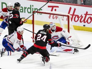 Canadiens goaltender Jacob Fowler tracks the puck as Senators' Dylan Cozens falls to the ice during third period in Ottawa on Wednesday.