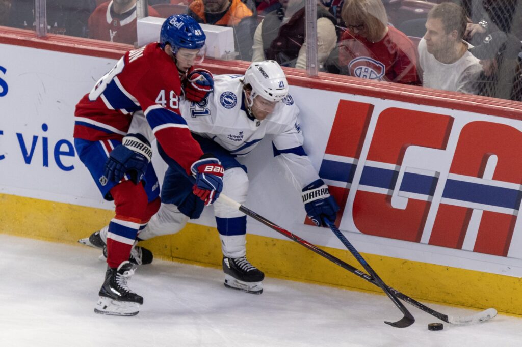 Montreal Canadiens' Lane Hutson pokes the puck away from Tampa Bay Lightning Brayden Point