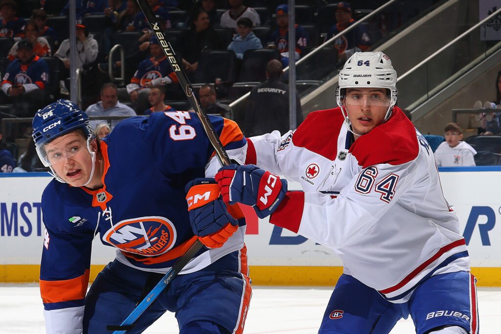 David Reinbacher of the Montreal Canadiens checks Calum Ritchie of the New York Islanders.