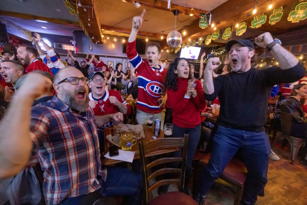 Canadiens fans, from left, François Mathieu, Maurice Pelletier, Dave Rhéaume, Andrea Criollo, and Hugo Sigouin-Plasse celebrate Kirby Dach's goal while watching their team's victory in Game 5 against the Tampa Bay Lightning at Champs bar in Montreal on Wednesday night.