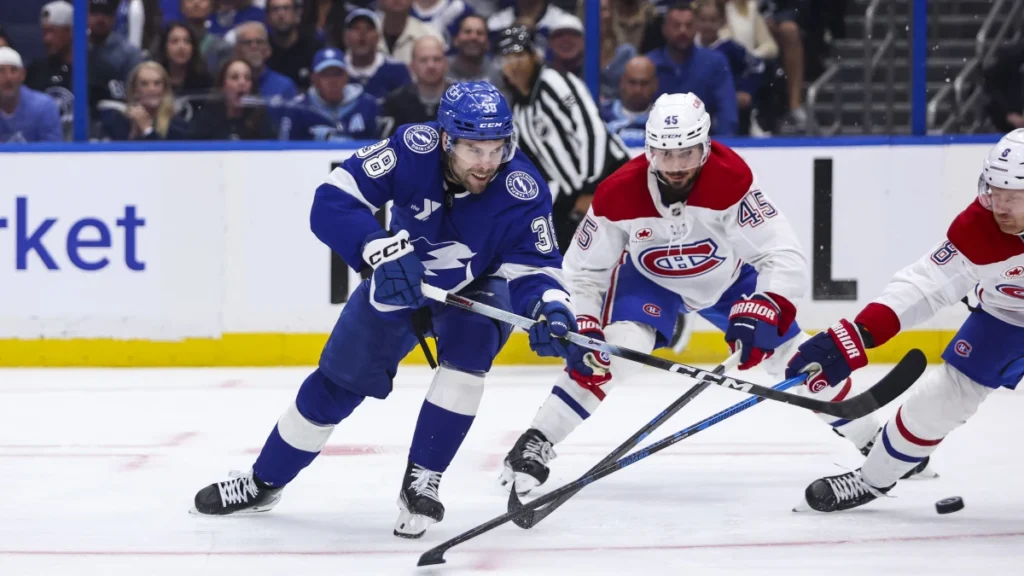Tampa Bay Lightning forward Brandon Hagel (38) takes a shot under pressure from Montreal Canadiens defenseman Lane Hutson (48) and defenseman Mike Matheson (8) during the third period in game one of the first round of the 2026 Stanley Cup Playoffs at Benchmark International Arena.