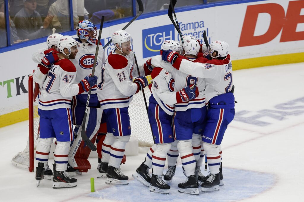 Canadiens players hug one another in groups after winning Game 7.
