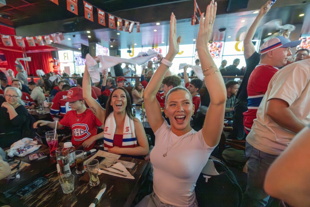 Canadiens fans Madison McLelland, right, and Melissa Ayotte celebrate a Habs goal while watching the Game 1 of Eastern Conference final against the Carolina Hurricanes at Brasserie des Rapides in LaSalle on Thursday night.
