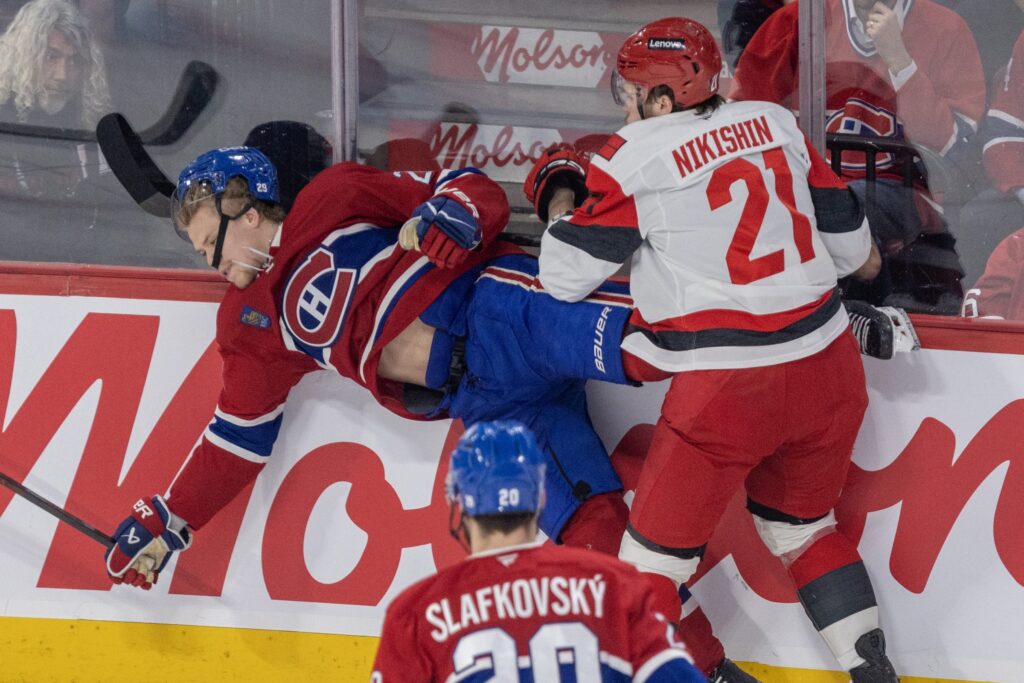 Carolina Hurricanes defenceman Alexander Nikishin levels Canadiens blue-liner Kaiden Guhle during second period of Game 4 in Montreal on Wednesday.