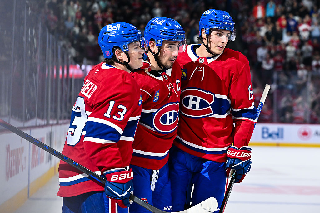 MONTREAL, CANADA - SEPTEMBER 23: Nick Suzuki #14 of the Montreal Canadiens celebrates his goal with teammates Cole Caufield #13 and David Reinbacher #64 during the second period in a preseason game against the Philadelphia Flyers at the Bell Centre on September 23, 2025 in Montreal, Quebec, Canada. (Photo by Minas Panagiotakis/Getty Images)