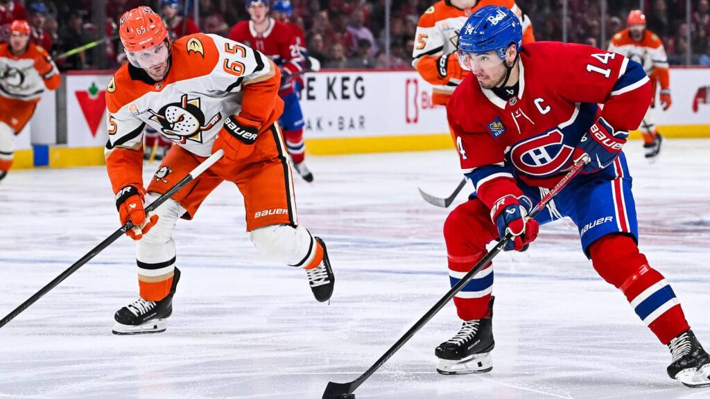Mar 15, 2026; Montreal, Quebec, CAN; Montreal Canadiens center Nick Suzuki (14) plays the puck against Anaheim Ducks defenseman Jacob Trouba (65) during the third period at Bell Centre. Mandatory Credit: David Kirouac-Imagn Images