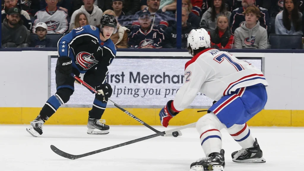 Columbus Blue Jackets left wing Kent Johnson (91) takes a shot as Montreal Canadiens defenseman Arber Xhekaj (72) during the first period at Nationwide Arena.