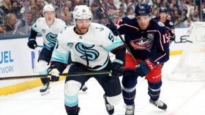 Mar 21, 2026; Columbus, Ohio, USA; Seattle Kraken center Shane Wright (51) and Columbus Blue Jackets defenseman Dante Fabbro (15) skate after a loose puck during the first period at Nationwide Arena. Mandatory Credit: Russell LaBounty-Imagn Images