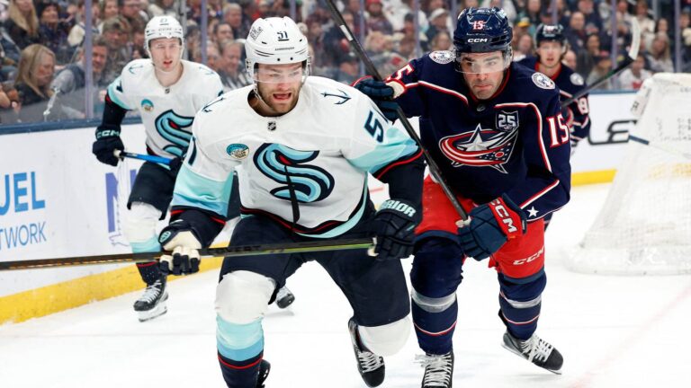 Mar 21, 2026; Columbus, Ohio, USA; Seattle Kraken center Shane Wright (51) and Columbus Blue Jackets defenseman Dante Fabbro (15) skate after a loose puck during the first period at Nationwide Arena. Mandatory Credit: Russell LaBounty-Imagn Images