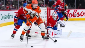 Anaheim Ducks center Leo Carlsson (91) plays the puck against Montreal Canadiens defenseman Alexandre Carrier (45) near goalie Jacob Fowler (32) net during the second period at Bell Centre.