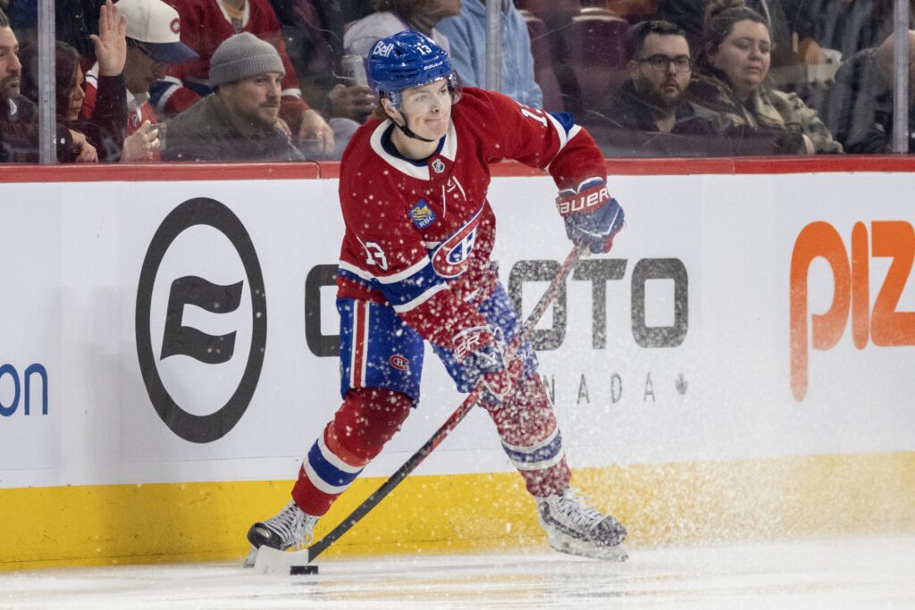 Canadiens winger Cole Caufield is seen near the boards in the offensive zone with the puck on his stick as he is about to pass.