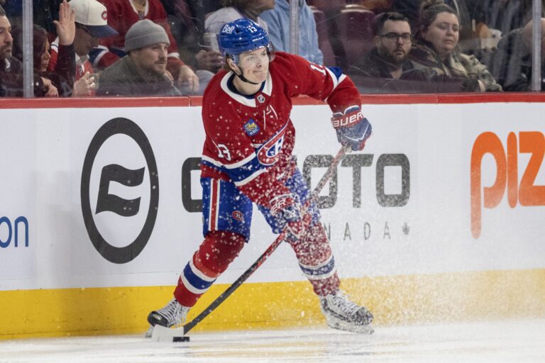 Canadiens winger Cole Caufield is seen near the boards in the offensive zone with the puck on his stick as he is about to pass.