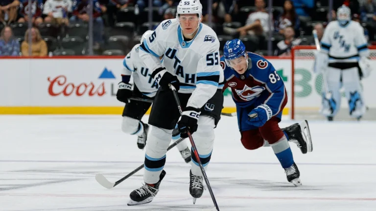 Utah Mammoth defenseman Maksymilian Szuber (55) controls the puck ahead of Colorado Avalanche center Nikita Prishchepov (85) in the third period at Ball Arena.