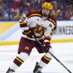 Apr 6, 2023; Tampa, Florida, USA; Minnesota defenseman Luke Mittelstadt (20)controls the puck against Boston University in the first period in the semifinals of the 2023 Frozen Four college ice hockey tournament at Amalie Arena. Mandatory Credit: Nathan Ray Seebeck-USA TODAY Sports