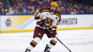 Apr 6, 2023; Tampa, Florida, USA; Minnesota defenseman Luke Mittelstadt (20)controls the puck against Boston University in the first period in the semifinals of the 2023 Frozen Four college ice hockey tournament at Amalie Arena. Mandatory Credit: Nathan Ray Seebeck-USA TODAY Sports