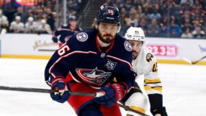 Apr 12, 2026; Columbus, Ohio, USA; Columbus Blue Jackets right wing Kirill Marchenko (86) and Boston Bruins defenseman Jonathan Aspirot (45) skate after a loose puck during the first period at Nationwide Arena. Mandatory Credit: Russell LaBounty-Imagn Images