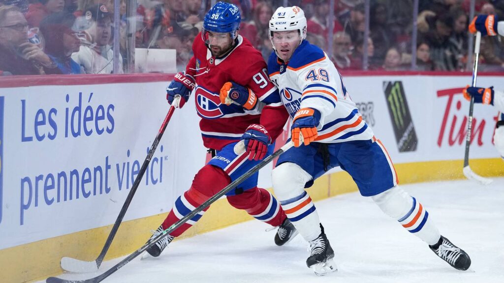 Dec 14, 2025; Montreal, Quebec, CAN; Edmonton Oilers defenseman Ty Emberson (49) plays the puck defended by Montreal Canadiens forward Joe Veleno (90) during the third period at the Bell Centre. Mandatory Credit: Eric Bolte-Imagn Images