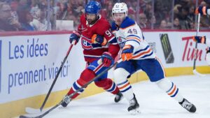 Dec 14, 2025; Montreal, Quebec, CAN; Edmonton Oilers defenseman Ty Emberson (49) plays the puck defended by Montreal Canadiens forward Joe Veleno (90) during the third period at the Bell Centre. Mandatory Credit: Eric Bolte-Imagn Images